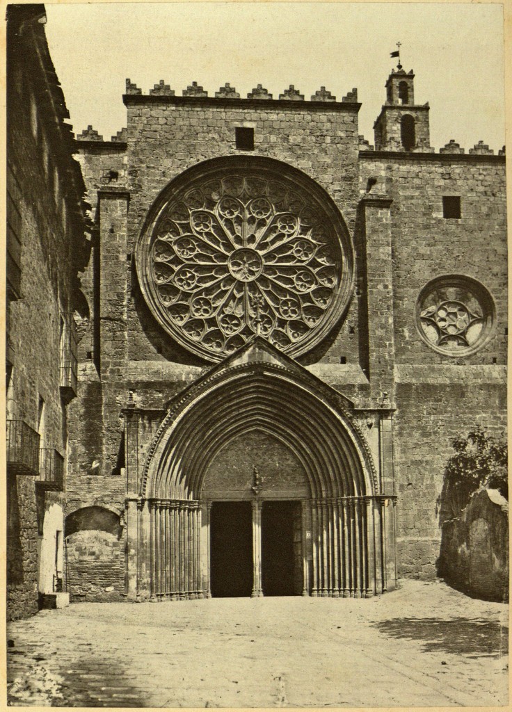 'Façana del monestir de Sant Cugat del Vallès', fotografia d'Heribert Mariezcurrena (~1878). Estampa núm. 8, acompanyada de text explicatiu, a l'Album Pintoresch-Monumental de Catalunya: aplech de vistas dels més notables monuments i paisatjes d'aquesta terra acompanyadas de descripcions y noticias históricas y de guias pera que sían fácilment visitats, publicat per l'Associació Catalanista d'Excursions Científiques el 1878. De disposició lliure al dipòsit digital de documents de la UAB. PD By Pedraferit. 