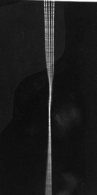 Fig. 63. Streak camera recording with image slit focused across (horizontal direction) six 5-MA current-conducting plasma columns. Time runs from top to bottom, with the columns converging and twisting at the center before separating. Streak photograph by A. L. Peratt, Los Alamos National Laboratory.